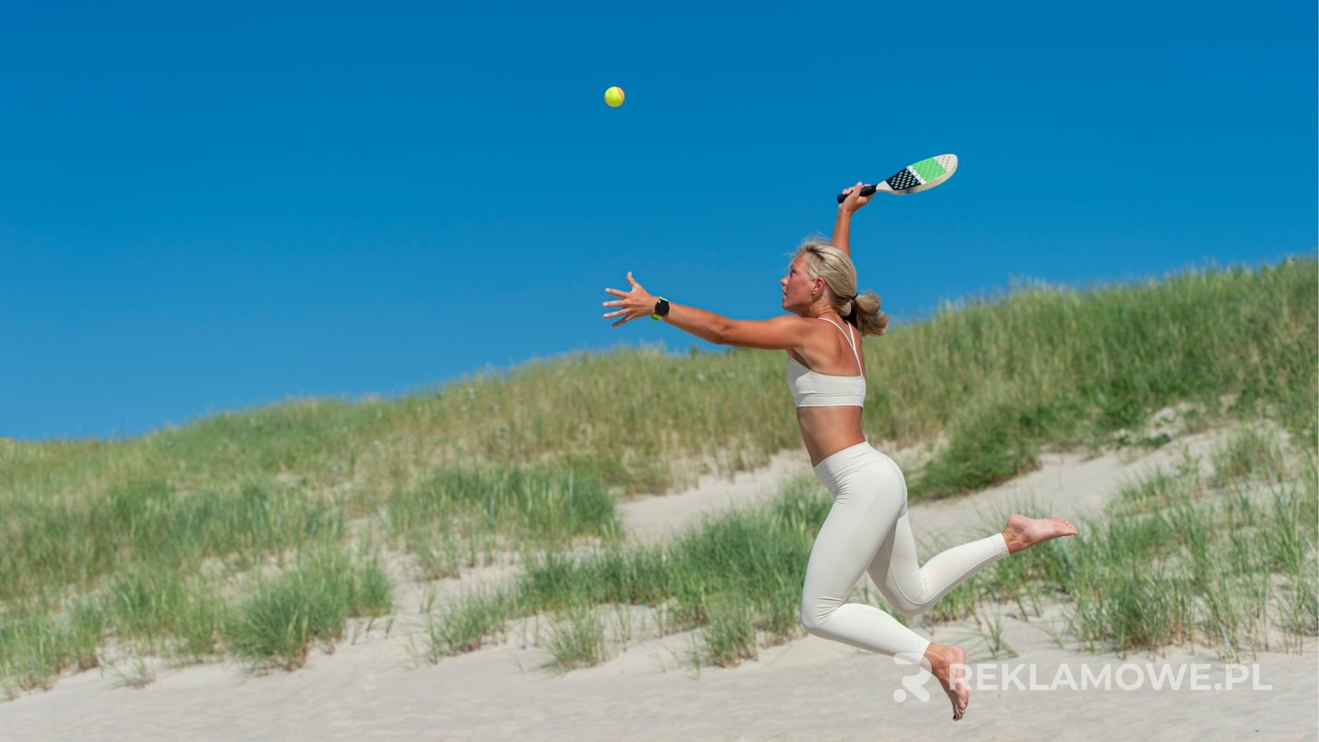 Piłka nożna z logo firmy leżąca na boisku